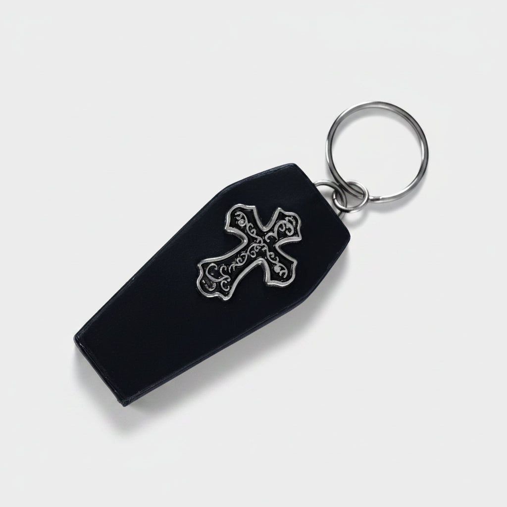 A black leather keychain with an engraved cross and coffin shape at the center.