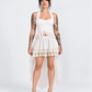 Tattooed model wearing a white pearl-trim halter corset with a layered lace high-low skirt.