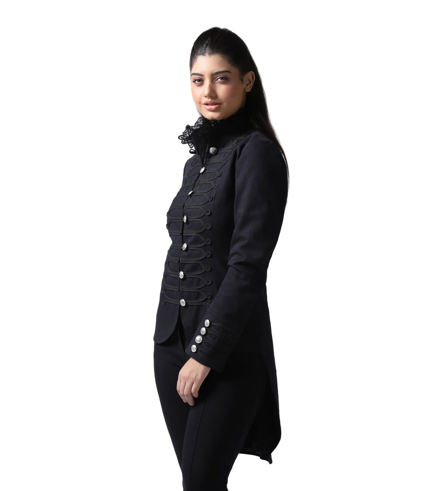 A woman modeling a black longline military-style jacket with ornate button details, a high ruffled collar, and matching black trousers against a plain white background.