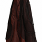 Side view of a model wearing a dark brown satin Victorian maxi skirt with a black sheer mesh overlay, ruching and lace trim.

