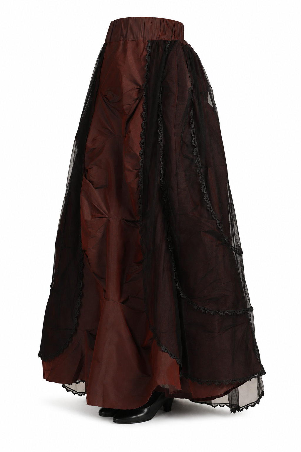 Side view of a model wearing a dark brown satin Victorian maxi skirt with a black sheer mesh overlay, ruching and lace trim.


