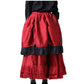 A red tiered skirt with black ruffle trim, shown on a model from the back against a white background.