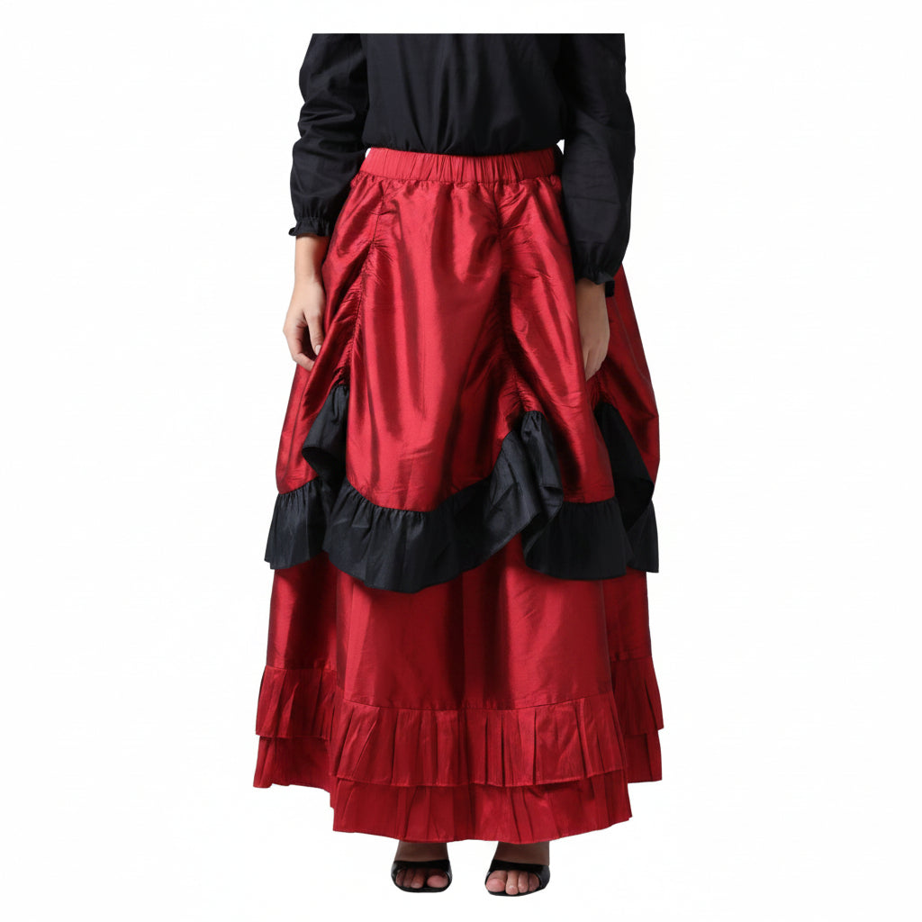 A red tiered skirt with black ruffle trim, worn by a model in a black top and black sandals, shown against a plain white background.