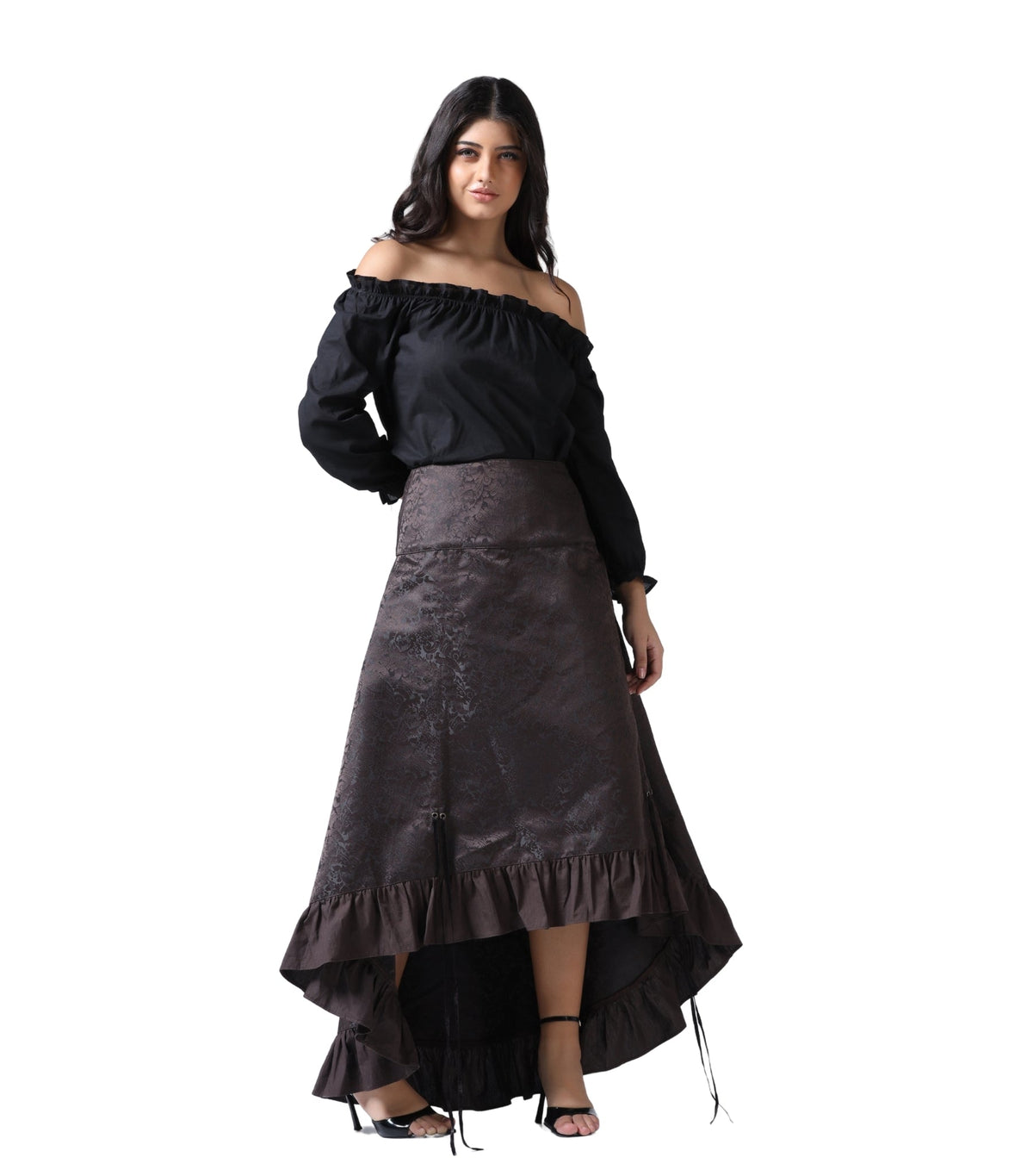 A woman modeling a black off-the-shoulder long-sleeve blouse paired with a dark brown high-low satin skirt with ruffle details, set against a plain white background.