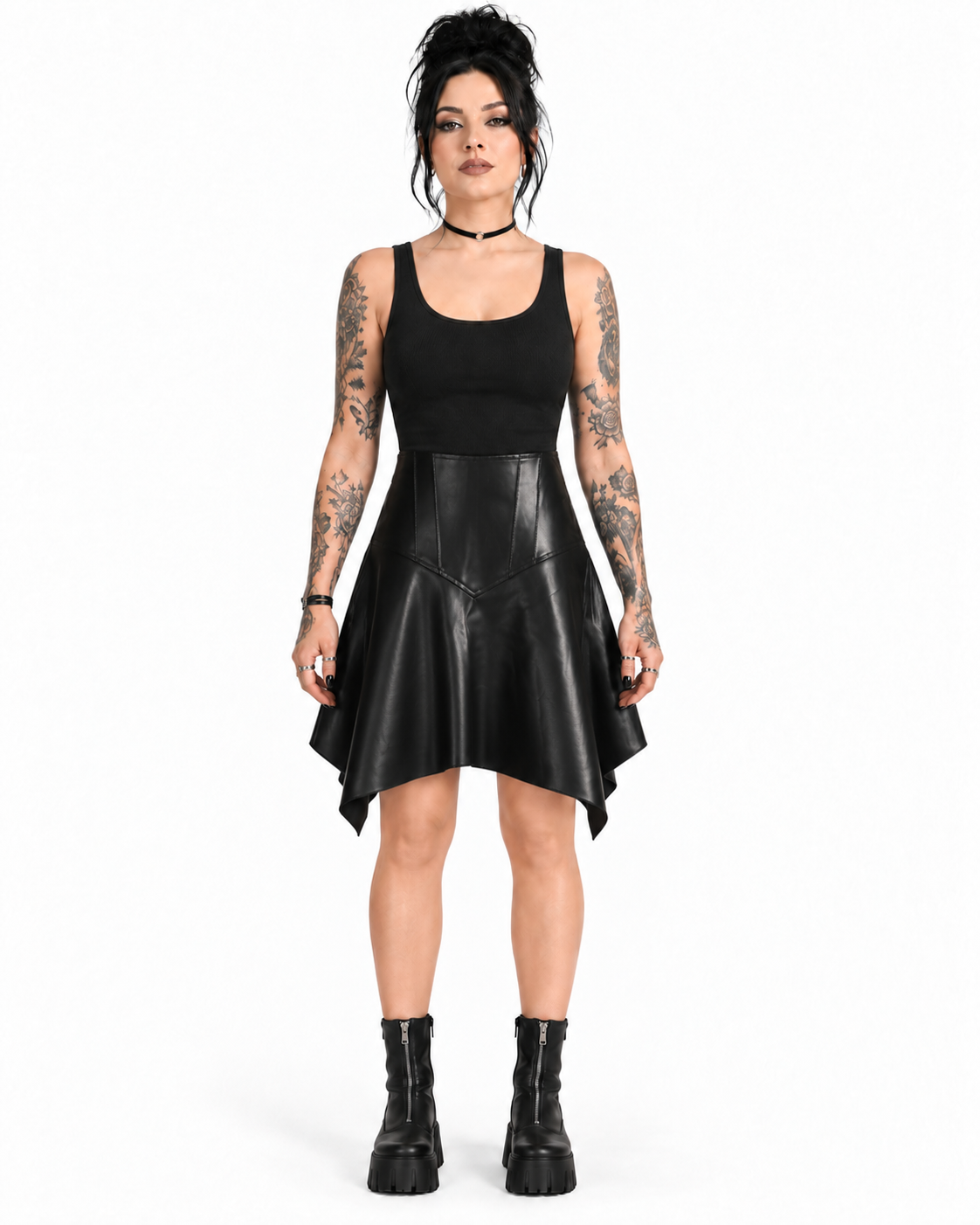 Front view of a model wearing a black PU asymmetrical skirt with a sculpted V-panel waist and pointed handkerchief hem.