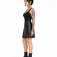 Side view of a tattooed model wearing a black PU Gothic skirt with visible eyelet lacing, side slit and tied ribbon ends.